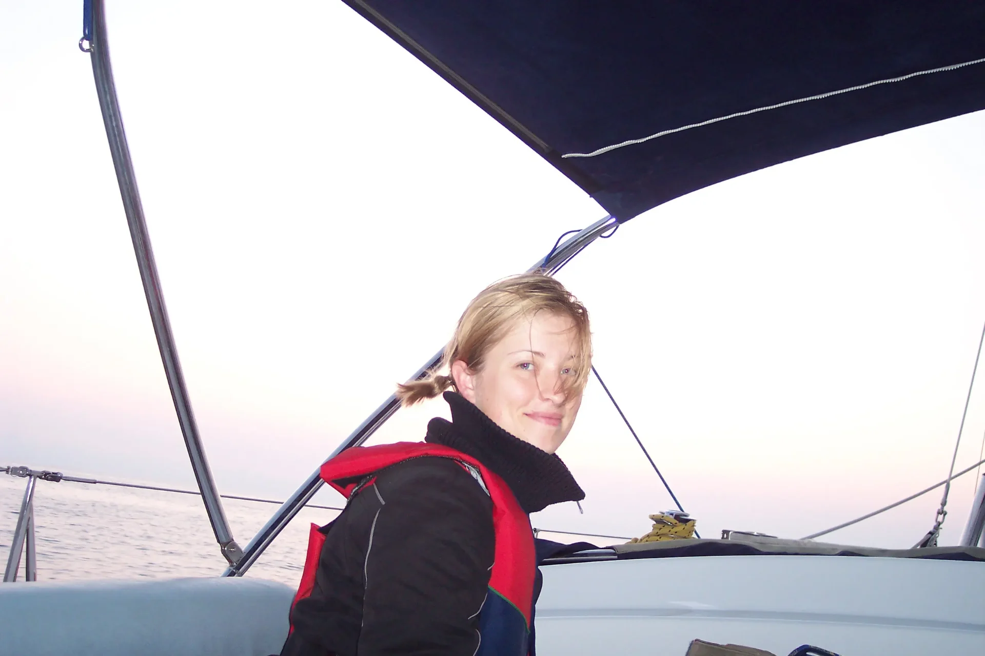 Kristina Agustin sailing at dusk during her early maritime career - open ocean, life jacket, looking back over her shoulder